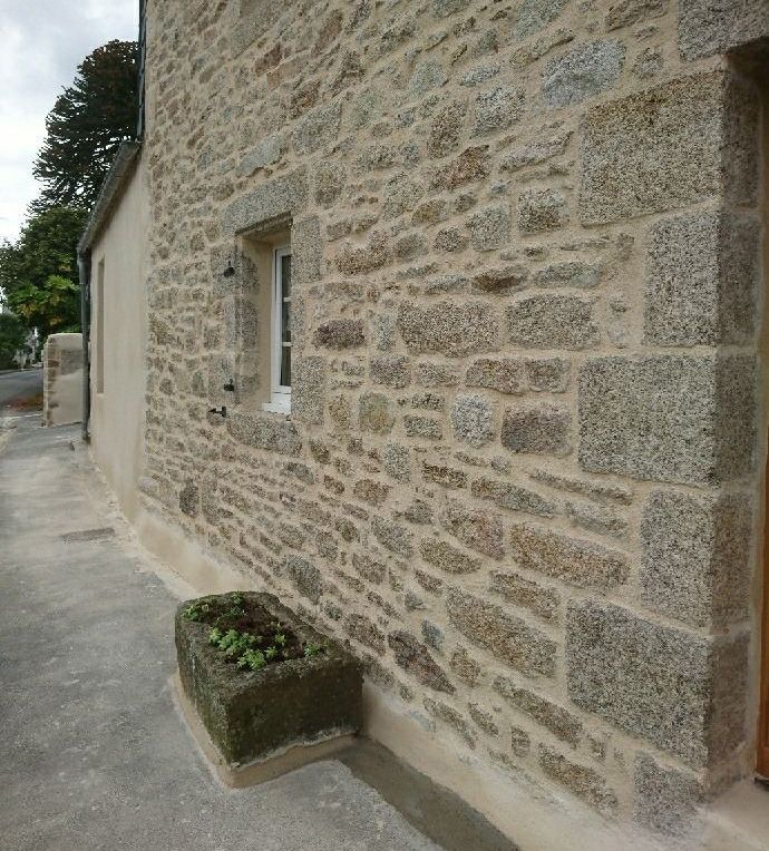 Travail de la pierre sur mur de maison ancienne dans le Finistère Nord